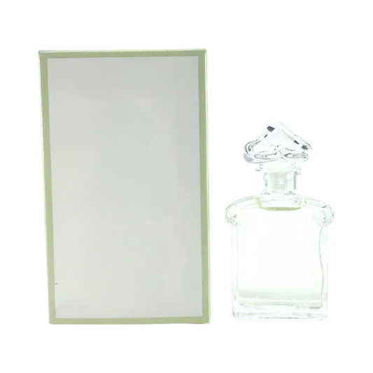 Clear decorative glass bottle with ornate stopper, empty for home decor, beside light green box