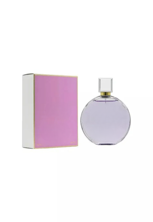 Empty decorative glass bottle with purple hue, square cap, beside pink gift box — home decor