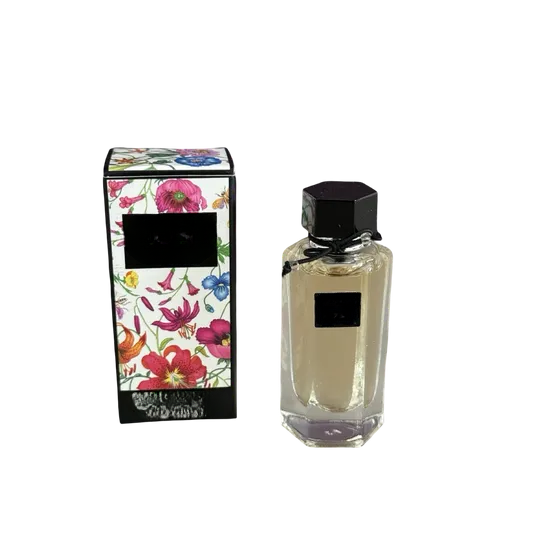 Empty decorative glass bottle with black cap, floral box, home decor accent