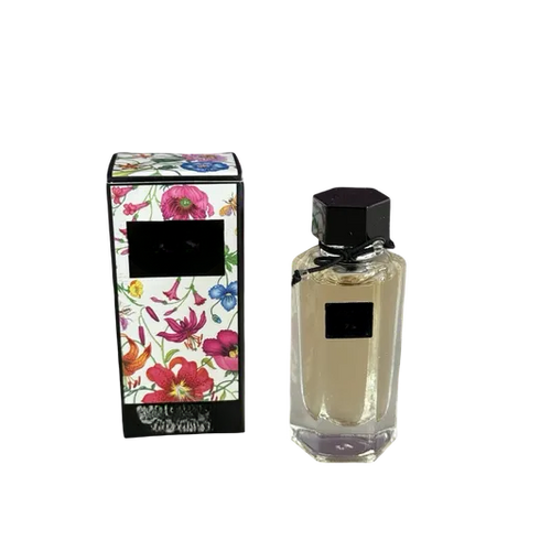 Empty decorative glass bottle with black cap, floral box, home decor accent