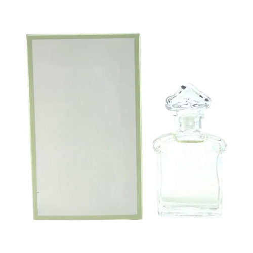 Clear decorative glass bottle with ornate stopper, empty for home decor, beside light green box